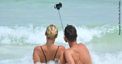 Couple de dos à la plage prenant un selfie